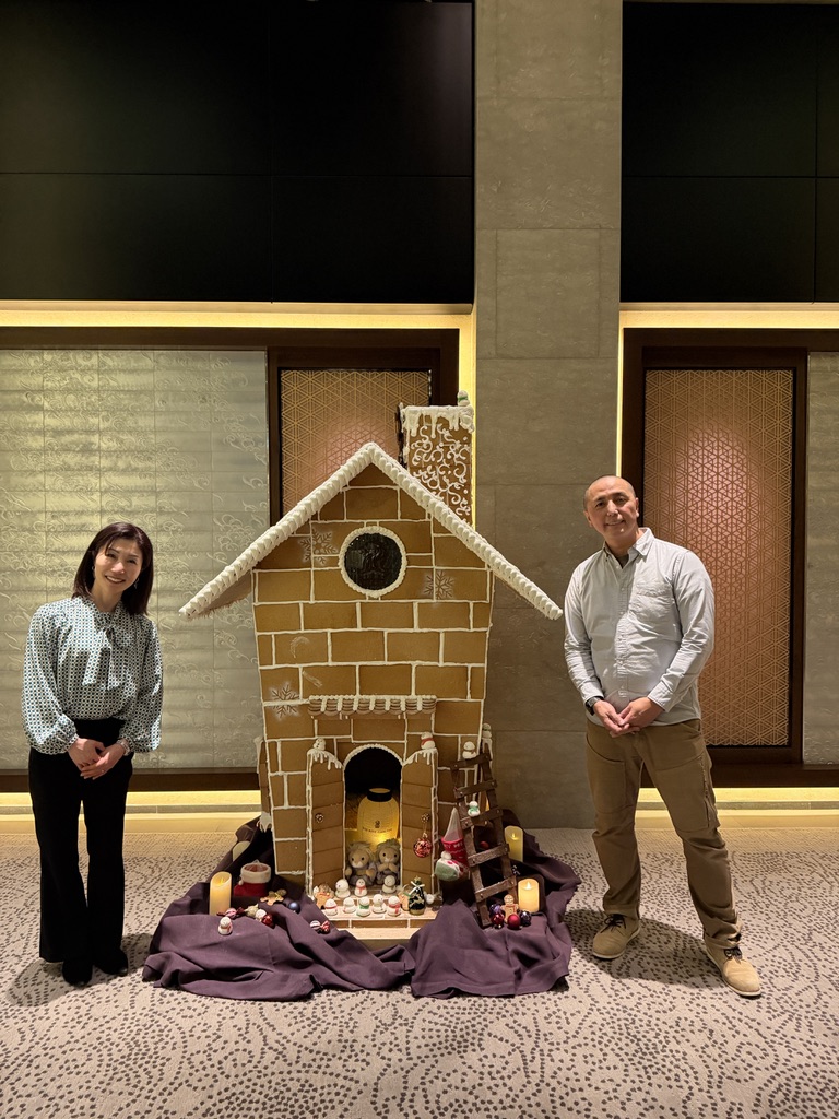 リッツカールトン京都のお菓子の家(ジンジャーブレッドハウス)の前で記念撮影する夫婦