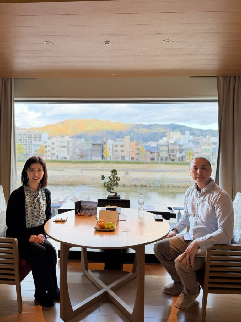 鴨川ビューの客室で微笑む夫婦のツーショット