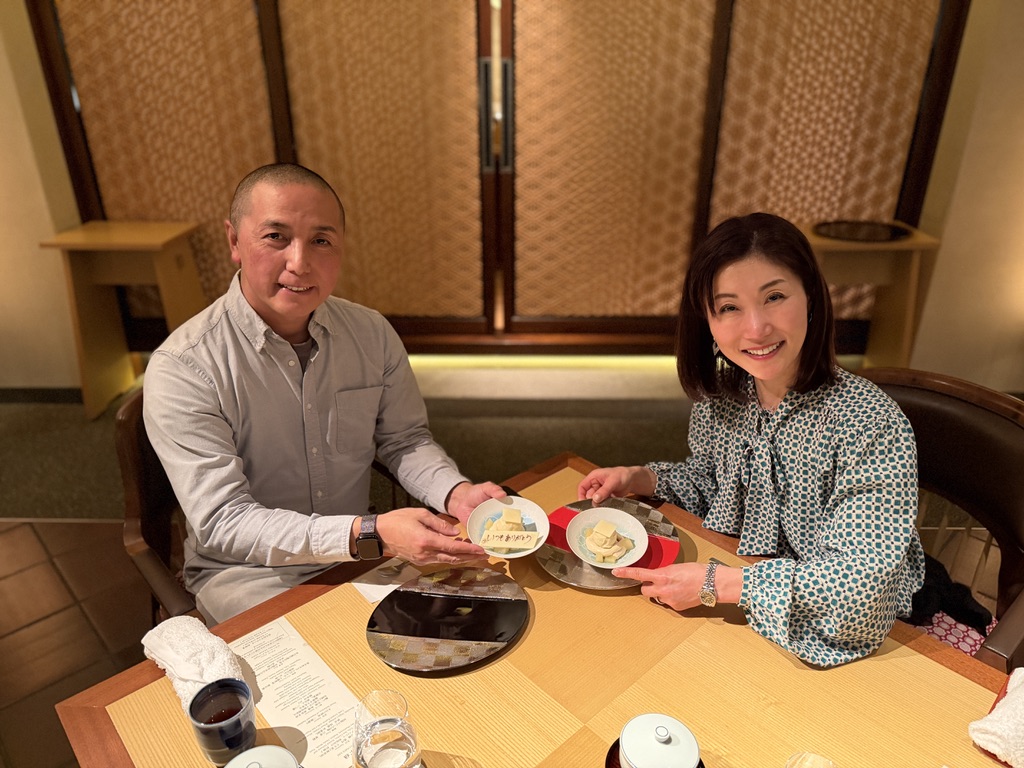 サプライズプレートを持って笑顔で写る夫婦の全体写真。水暉にて