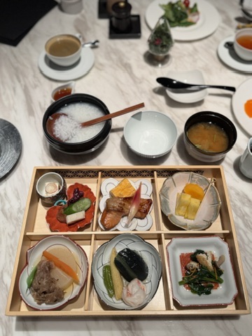 水暉の和朝食膳。湯豆腐や焼き魚、小鉢が並ぶ。